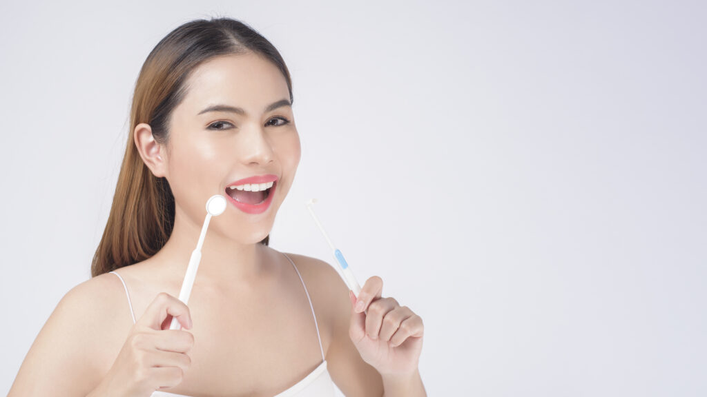 Young smiling woman holding invisalign braces in studio, dental healthcare and orthodontic concept